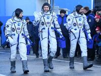 Members of the International Space Station (ISS) expedition 58/59, walk to report to Dmitry Rogozin (unseen), the head of the Russian space agency Roscosmos, prior to the launch onboard the Soyuz MS-11 spacecraft at the Russian-leased Baikonur cosmodrome in Kazakhstan on December 3, 2018. 
Kirill KUDRYAVTSEV / POOL / AFP