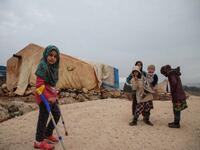 Syrian Maya Merhi poses for a picture next to her prosthetic legs that are decorated with the Turkish flag inside a tent at the Internally Displaced Persons (IDP) camp of Serjilla in northwestern Syria. 
Aaref WATAD / AFP