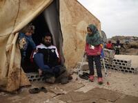 Maya Merhi (R) stands with the support of crutches next to her disabled father (C) outside their tent in the Internally Displaced Persons (IDP) camp of Serjilla in northwestern Syria next to Bab al-Hawa border crossing with Turkey.
Aaref WATAD / AFP