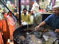  Pakistani cook grills kebabs while customers look on at the Tory Kebab House in Namak Mandi in Peshawar.
ABDUL MAJEED / AFP