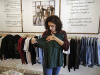 Palestinian fashion designer Yasmeen Mjalli speaks while standing in her clothing shop where her label collection "BabyFist" carrying anti-sexual harassment slogans is showcased, in Ramallah 
ABBAS MOMANI / AFP
