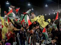 People wave flags of Palestine and Fatah as they attend a mass wedding ceremony 
Mahmoud ZAYYAT / AFP
