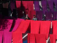 A Pakistani worker dries fabric threads after dyeing them at a factory in Lahore (Twitter)