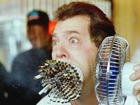 Jim Mouth uses a fan to blow smoke from 155 cigarettes as he breaks “The Guinness Book of World Records” record November 18, 1993 for smoking the most cigarettes at the same time. (AFP/ File Photo)