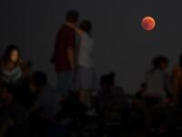 People watch the total lunar eclipse in the Olympic park in Munich, southern Germany, on July 27, 2018. (AFP, CHRISTOF STACHE)