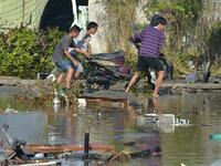 People salvage a motorcyle in Palu, Indonesia's Central Sulawesi on September 30, 2018, following the September 28 earthquake and tsunami.(ADEK BERRY / AFP)