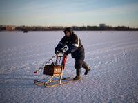 A man going ice-fishing slides on a vintage sled carrying a powerdrill and his fishing gear on the frozen Bothnia Sea, on December 28, 2016 in Vaasa, Western Finland. (OLIVIER MORIN/AFP)