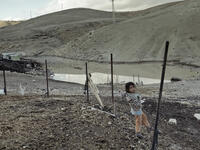 tiny Palestinian girl at the security fence