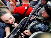 applying lipstick using riot police shield 'mirror'