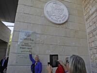 A woman poses for a picture next to an inauguration plaque during the opening of the US embassy in Jerusalem on May 14, 2018. Palestinian anger and exuberant praise from Israelis over President Donald Trump's decision tossing aside decades of precedent.
Menahem KAHANA / AFP