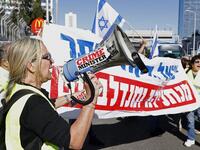 An Israeli protester wearing a yellow vest uses a loudspeaker to shout slogans during demonstrations against the rising cost of living on December 14, 2018.
JACK GUEZ / AFP