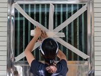 A resident tapes up her front entrance window in the fishing village of Tai O in Hong Kong on September 15, 2018, a day before the arrival of Super Typhoon Mangkhut. 
Anthony WALLACE / AFP
