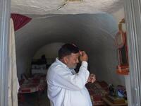 Pakistani villager Haji Abdul Rasheed combs his hair at the entrance to his cave room in Nikko village. 
AAMIR QURESHI / AFP