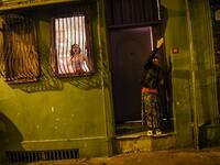 A transgender looks out of a window and a woman reacts as women's rights activists march through Taksim Square to protest against gender violence in Istanbul, on November 25, 2018, on the International Day for the Elimination of Violence against Women. 
BULENT KILIC / AFP