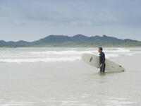 Young man going to surf in Tamarindo, Costa Rica. Tamarindo is located on the Northern Pacific Coast and a leading surfer hotspot. (Shutterstock)