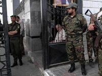 Palestinian security forces loyal to Hamas (right) stand guard outside the Rafah border crossing with Egypt, as security forces loyal to the Palestinian Authority stand guard inside (left), in the southern Gaza Strip. 
Said Khatib / AFP
