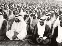 Men reciting prayers for the Muslim festival of Eid in Dubai, ca. 1960s