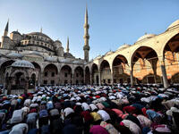 Muslim worshippers gather to perform Eid el-Fitr prayers at the Blue mosque in Istanbul on June 25, 2017. The Blue mosque, while a famous tourist side, is still used for prayers and closes for visitors during praying hours. 