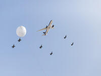 A Royal Jordanian commercial plane flies overhead, flanked by fighter jets from Jordan's air force as part of celebrations marking the centennial of the Great Arab Revolt in Amman.