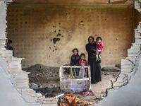 Turkey’s descent into war: A woman and her children stand in the ruins of battle-damaged house in the Kurdish town of Silopi, in southeastern Turkey, near the border with Iraq on January 19, 2016. 
