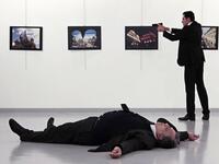 This picture taken on December 19, 2016 shows Andrei Karlov, the Russian ambassador to Ankara, lying on the floor after being shot by Mevlut Altintas (R) during an attack at a public event in Ankara. 