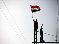 Flag waving and victory signs are the order of the day at the top of the electricity pole (AFP)