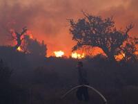 Israeli firefighters work on the slope of a burning hill in Tirat Ha Carmel near the northern city of Haifa