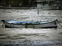 A fishing boat floats in wavy waters in the Lebanese ancient Mediterranean port of Byblos as heavy winds and rain whipped across Lebanon, grounding flights, knocking down billboards and causing nationwide traffic jams in the first winter storm to hit the country after months of drought.