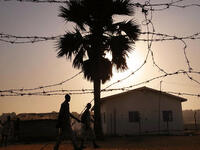 Men walk down a road in an area for displaced Sudanese in the southern Sudanese city of Juba, Sudan.