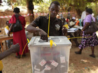 A man places his vote in a plastic box at a polling station.