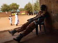 A south Sudanese police officer guards a polling station.