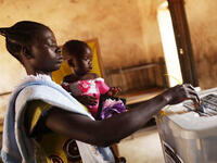 A woman votes with her daughter at a polling station.