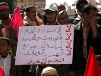 Placard reads: "No Despotism and Unfairness, No to Power Inheritance and Extension No to Starvation Policy, No to Theft of Resources Yes for Change".