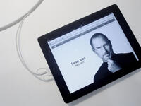 An Apple "iPad 2"-displayed obituary is more fitting a commemoration than an engraved headstone might be. On
hearing of his death, wherever in the world or whatever time zone, fans left flowers in Apple stores as the natural point for paying respects. A reseller in Singapore, Epicenter, literally became center-point for 'Apple Evangelists’.