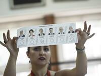 An election committee member shows a ballot displaying a vote for Recep Tayyip Erdogan, Turkish President and leader of the Justice and Development Party (AKP) at a polling station during the Turkish presidential and parliamentary elections in Istanbul on June 24, 2018. (Yasin AKGUL / AFP)