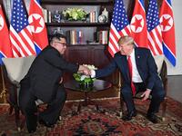 US President Donald Trump (R) shakes hands with North Korea's leader Kim Jong Un (L) as they sit down for their historic US-North Korea summit, at the Capella Hotel on Sentosa island in Singapore on June 12, 2018. (SAUL LOEB / AFP)