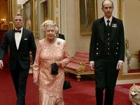 الملكة إليزابيث: خلال حفل افتتاح الألعاب الأولمبية الصيفية في لندن 2012 ظهرت ملكة بريطانيا إليزابيث الثانية في لقطة مع جيمس بوند، الذي وصل إلى القصر الملكي في سيارة أجرة ليرافقها في طائرة مروحية.
