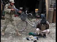 رجل أمن أفغاني يصوب سلاحه تجاه رجل اتهم بتخطيطه لتفجير انتحاري في مدينة جلال أباد بأفغانستان.