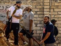 Libyan fighters loyal to the Government of National Accord (GNA) hold rocket-propelled grenade (RPG) launchers as they stand behind a dirt barrier during clashes with forces loyal to strongman Khalifa Haftar south of the capital Tripoli's suburb of Ain Zara, on April 10, 2019. Mahmud TURKIA / AFP