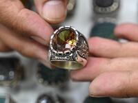 Hadi Ekhlas, engraver, holds one of his work on his hand at his workshop at the Grand Bazaar in Istanbul.  OZAN KOSE / AFP