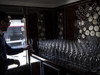This picture taken on May 13, 2019 shows a bartender lining up glasses in the dining car of a restored carriage of an Orient Express train displayed at the Gare de l'Est train station in Paris.  Christophe ARCHAMBAULT / AFP