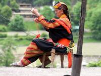 In this picture a Kalash woman wearing a traditional dress knits clothes outside her house after celebrating 'Joshi', a festival to welcome the arrival of spring, at Bumburate village in the mountainous valleys in northern Pakistan. AAMIR QURESHI / AFP