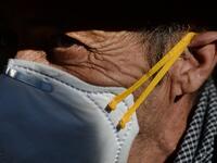 A pilgrim wearing a mask awaits the effigy of the Rocio Virgin during a procession at the village of El Rocio  CRISTINA QUICLER / AFP