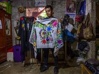 Mexican artisan of the Otomi ethnic group Oliver Teodoro Lopez, shows one of his designs at his workshop in San Nicolas Village, in Tenango de Doria, Hidalgo state, Mexico.  Pedro PARDO / AFP