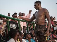 A Sudanese wrestler receives money from spectators after winning during a traditional Nuba wrestling match at the Haj Youssef stadium in the district of Khartoum.  Yasuyoshi CHIBA / AFP