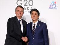 Brazil's President Jair Bolsonaro (L) is welcomed by Japan's Prime Minister Shinzo Abe to the G20 Summit in Osaka on June 28, 2019.  Ludovic MARIN / POOL / AFP