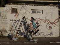Palestinian children play on a swing at Al-Shatee Refugee Camp in Gaza City on July 3, 2019.  MOHAMMED ABED / AFP