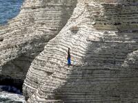 A cliff diver jumps from a platform on the landmark Raouche sea rock off the coast of the Lebanese capital Beirut on July 14, 2019, during the women's 2019 Red Bull Cliff Diving World Series.  ANWAR AMRO / AA / AFP