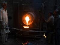Pakistani labourers pour melted metal into a cast at an iron factory in Karachi on April 30, 2019, on the eve of the International Labour Day celebrated on May 1.  ASIF HASSAN / AFP