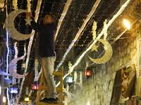 A Palestinian man decorates with lights near the entrance of the al-Aqsa mosque compound, in the old city of Jerusalem on May 4, 2019, as Muslims around the world prepare for the announcement of the fasting month of Ramadan. AHMAD GHARABLI / AFP